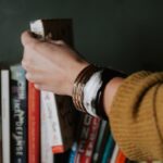 Illustratives Bild einer Hand, die ein Buch aus dem Bücherregal greift