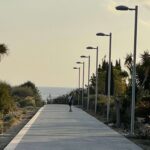 Ein Junge fährt Skateboard auf einer Strandpromenade