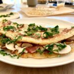 Bild eines zusammengeklappten Pfannkuchens mit Pilzen auf einem Teller