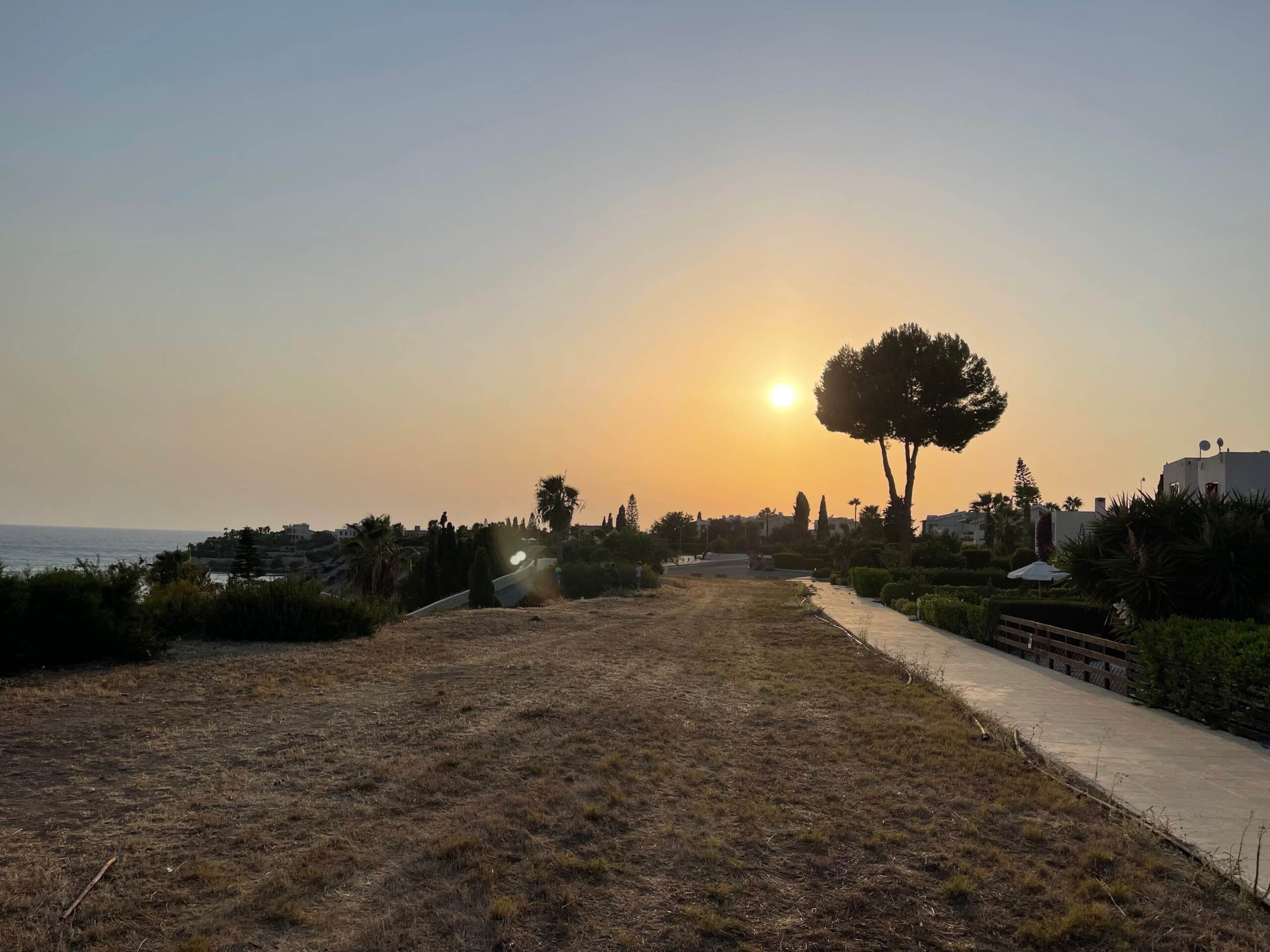 Sonnenuntergang vor einer urbanen Kulisse am Meer