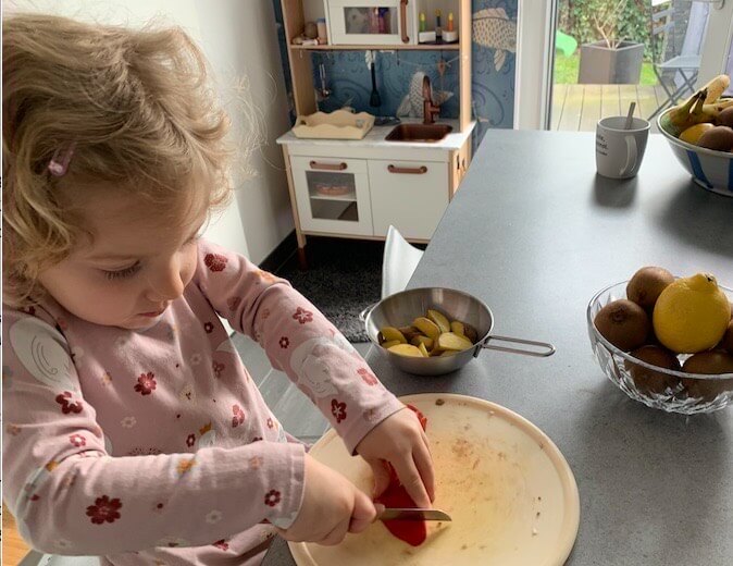 Kind schneidet Gemüse in der Küche